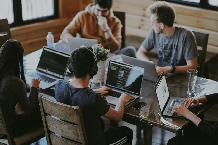 Nescom Technologies engineers collaborating around a laptop in a modern office